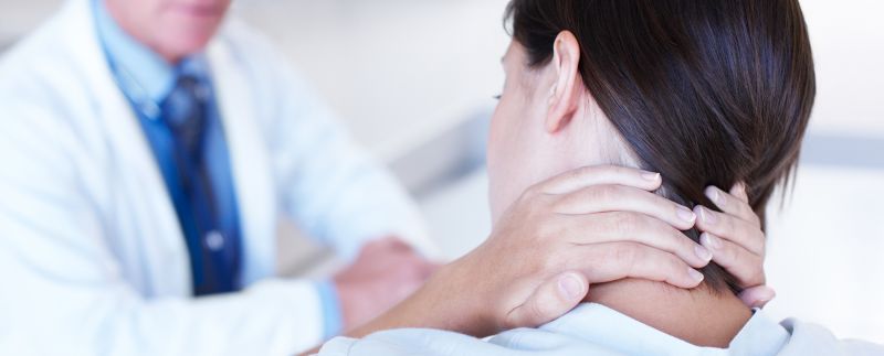 Patient with neck pain speaking to doctor