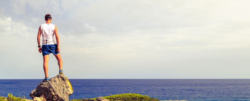 Man standing on rock in front of ocean