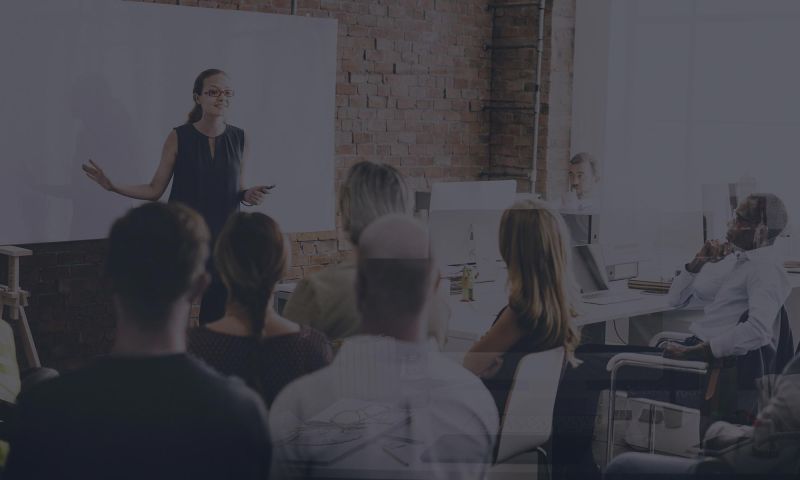 Woman in front of white board teaching and class